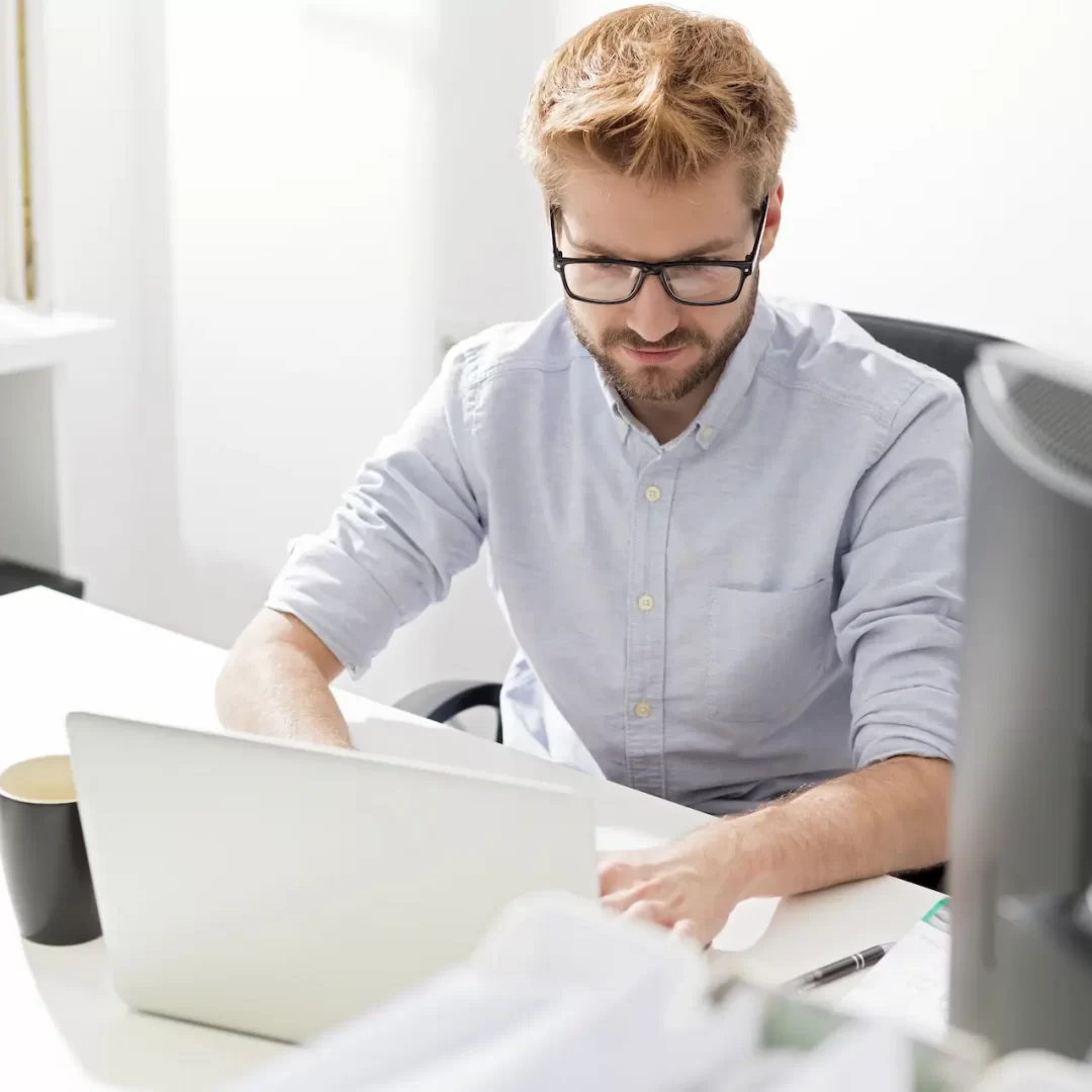 young-businessman-using-laptop-at-desk-2022-11-06-23-04-15-utc